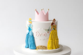 Cake with princess figures and a crown on a white background