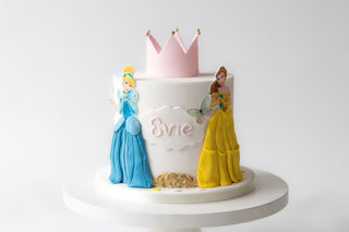 Cake with princess figures and a crown on a white background